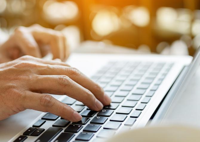 Hands typing on a laptop.