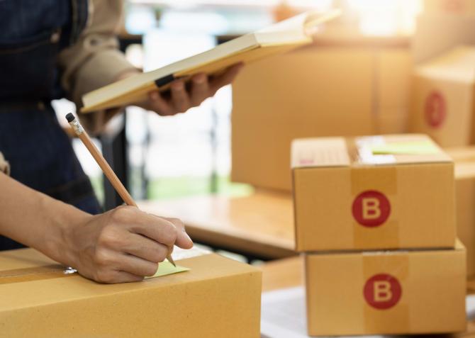 A person writing on a packaging.
