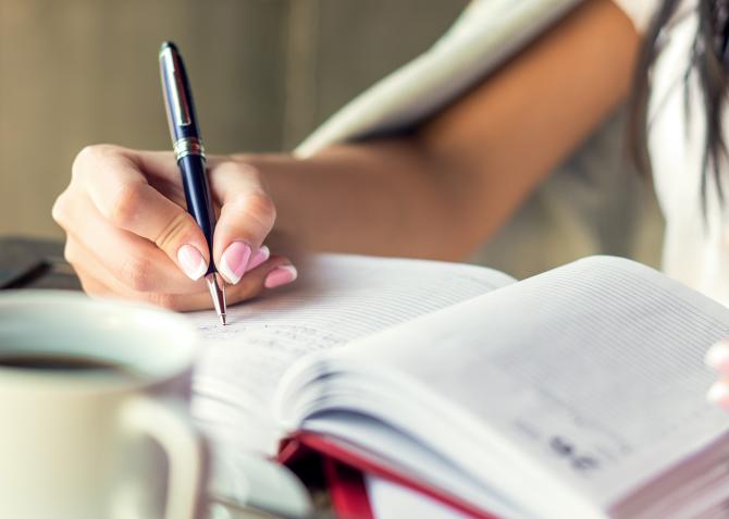 Woman's hand writing in planner 