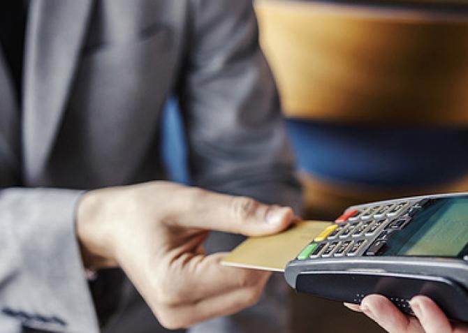 man in blazer paying for check with card machine