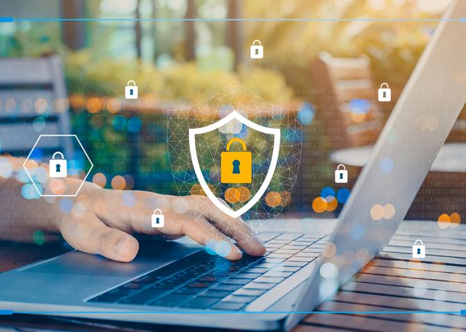 A person is using a laptop that has a cybersecurity icon superimposed over the image.