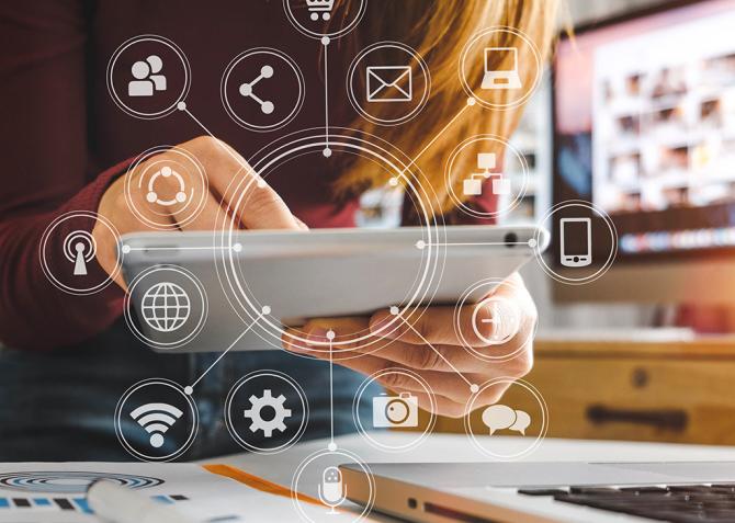 An entrepreneur works on a mobile device with icon illustrations superimposed on the image.