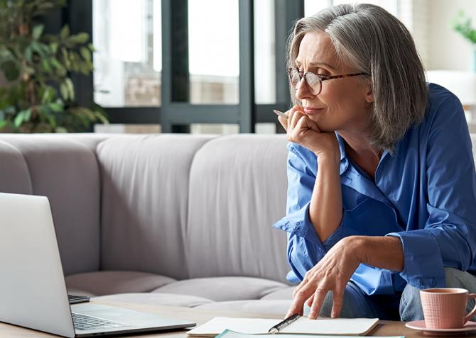 An entrepreneur researches training opportunities on a laptop.